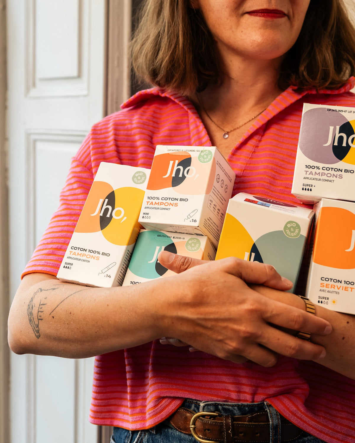 Bras chargés de boîtes de tampons et serviettes Jho