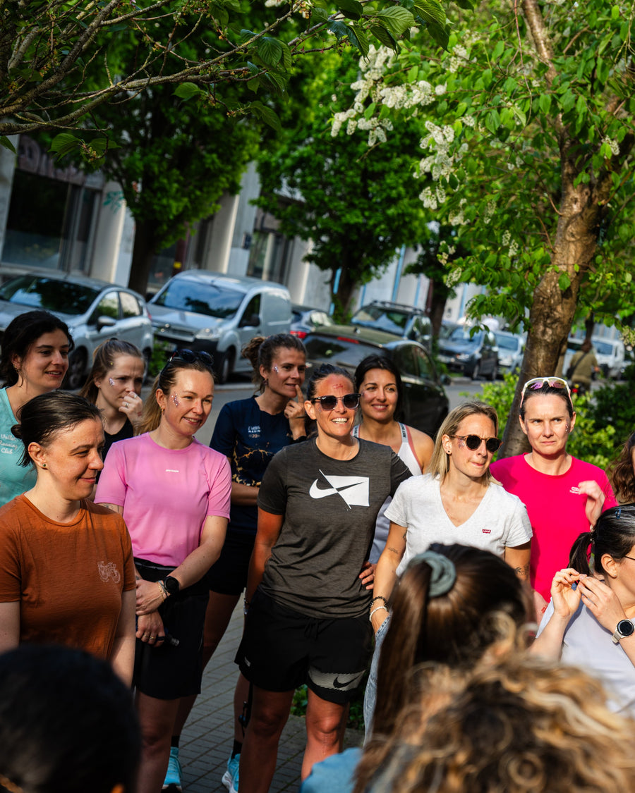 Un groupe de coureuses souriantes réunies avant le départ d'une sortie running